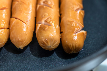 Close Up view of sausages fried in a pan, Sensitive Focus, Macro photo of food being cooked.