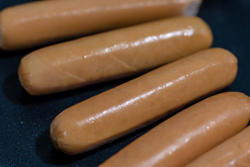 Close Up view of sausages fried in a pan, Sensitive Focus, Macro photo of food being cooked.