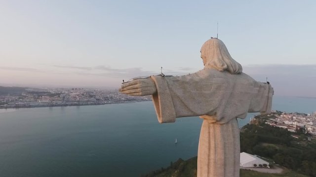 Aerial view of Santuario de Cristo Rei (Christ the King Portuguese Sanctuary) with general overlook of Lisbon, Almada and Ponte 25 de Abril (25th of April bridge) at sunset