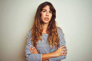 Fototapeta premium Young beautiful woman wearing stripes t-shirt over white isolated background skeptic and nervous, disapproving expression on face with crossed arms. Negative person.