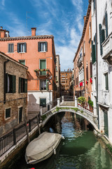 Fototapeta na wymiar Bridge over the narrow Venetian canal