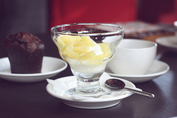 Dessert in the restaurant, ice cream with fruit and chocolate muffin, tea