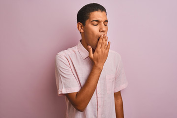 Young handsome arab man wearing casual shirt standing over isolated pink background bored yawning tired covering mouth with hand. Restless and sleepiness.