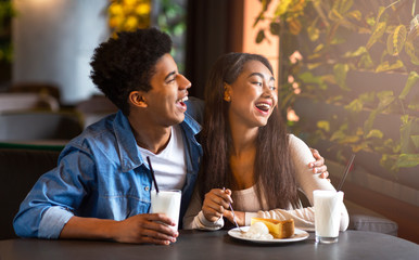 Afro guy and mixed race girl having date in cafe