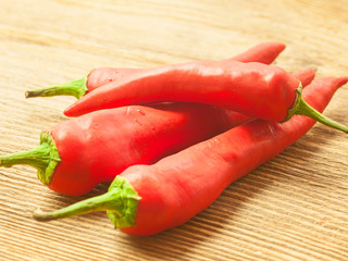Pods of red pepper lie on the table