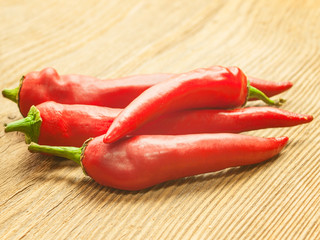 Pods of red pepper lie on the table