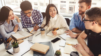 Classmates doing their project together, discussing material