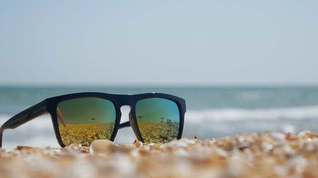 sunglasses lie on the sand and shells on the seashore.glasses lie on the beach.copy space. place for text.