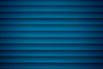 Texture of dark blue metal jalousie. Ribbed background with stripes, straight lines. Modern backdrop of striped fence.