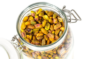 raw pistachio in a glass jar isolated on white