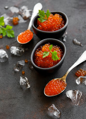 Fototapeta na wymiar Red caviar on a black background