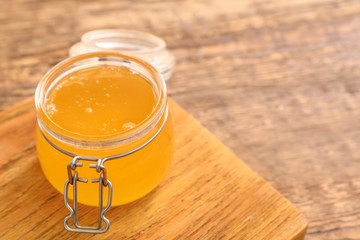 Jar of sweet honey on wooden background