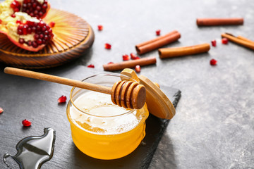 Jar of sweet honey and dipper on table