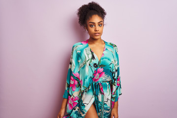 Young beautiful african american woman standing wearing elegant colorful caftan