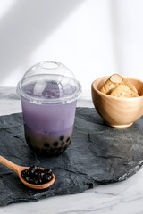 Bubble milk tea with milk  and bubble topping for tea or other beverage on the wood table with copy-space for text.