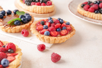 Sweet tartlets with berries on light table