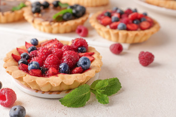 Sweet tartlet with berries on light table