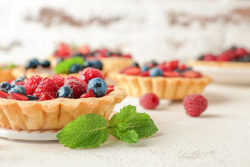 Sweet tartlet with berries on light table