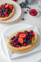 Sweet tartlets with berries on light table