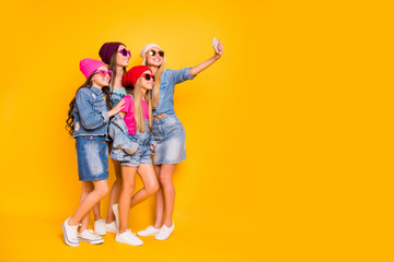 Full body photo of four cool confident charming nice glad funky in blonde brunette denim glamorous clothes girlfriend mom baddies fellows making self picture isolated yellow background with copyspace