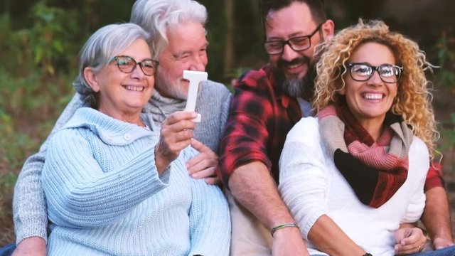 Group of mixed ages generations people smiling and showing blocks letters with  life word -  happy lifestye enjoying the outdoor leisure activity together family