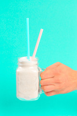 The concept of the amount of sugar in a glass of carbonated drinks. Man holding White sugar in the glass on menthol background.- Image