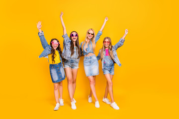 Full length body size photo of four amazing beautiful nice glad optimistic wearing casual denim street style apparel hipsters raising hands up having team feminine power isolated bright background