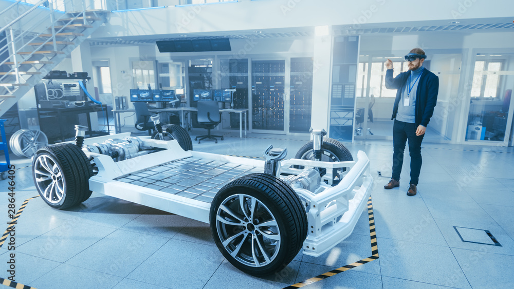 Poster automotive engineer working on electric car chassis platform, using augmented reality headset. in in