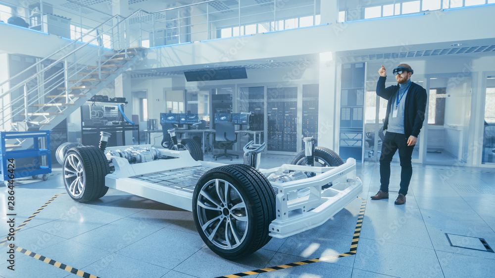 Poster automotive engineer working on electric car chassis platform, using augmented reality headset. in in