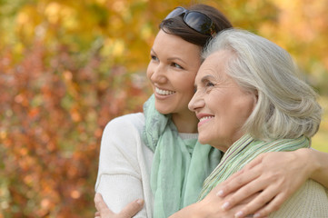 Portrait of senior woman with adult daughter in autumnal park