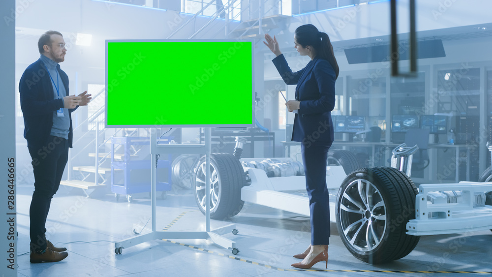 Poster male and female design engineers are discussing something on a interactive whiteboard with green scr