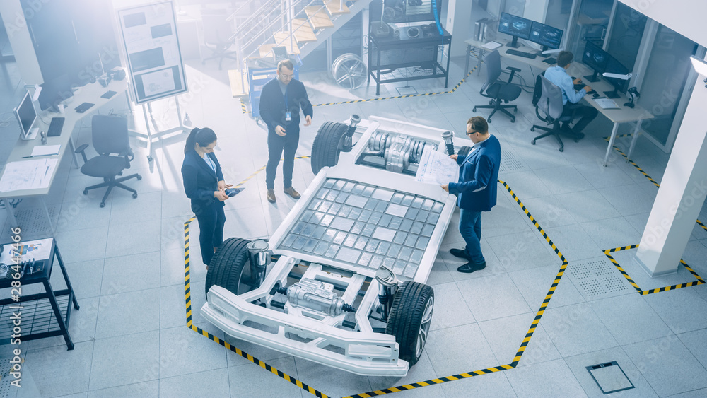 Poster team of automobile design engineers in automotive innovation facility. they are working on electric 
