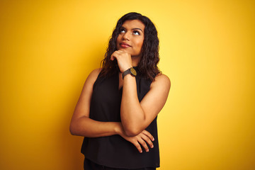 Fototapeta premium Transsexual transgender elegant businesswoman standing over isolated yellow background with hand on chin thinking about question, pensive expression. Smiling with thoughtful face. Doubt concept.