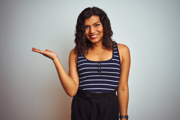 Transsexual transgender woman wearing striped t-shirt over isolated white background smiling cheerful presenting and pointing with palm of hand looking at the camera.