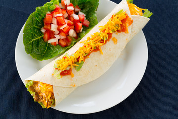 Burrito wrap with meat, cheese, lettuce, tomato and sour cream