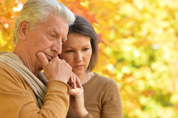 Portrait of sad woman and senior man hugging