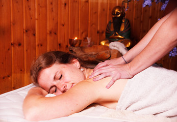 Obraz na płótnie Canvas A young woman having a Massage in a spa Salon center