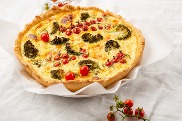 Quiche lorraine with broccoli on white