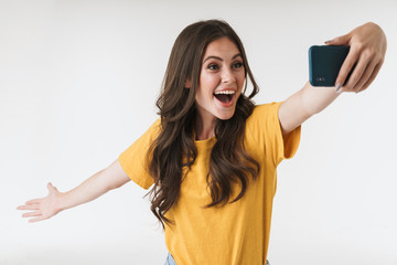 Naklejka premium Image of excited brunette woman laughing while taking selfie photo on cellphone