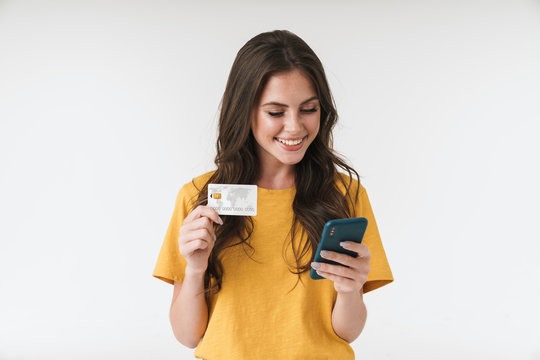 Image of gorgeous brunette woman wearing casual clothes holding credit card and cellphone