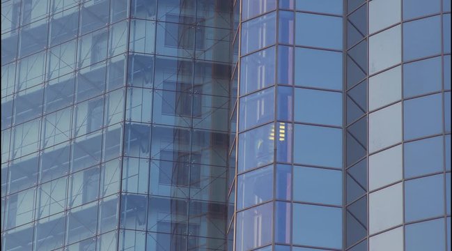 Glass Elevator Going Down the Glazed Facade of Skyscraper. Glass Curtain Facade Wall Background.