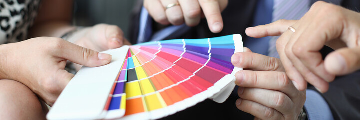 A group of designers holds business meeting on choosing colors for the customer office walls concept.