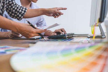 Two colleagues creative graphic designer working on color selection and drawing on graphics tablet at workplace, Color swatch samples chart for selection coloring