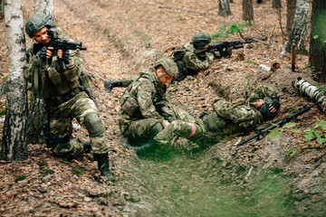 Bandaging a wounded soldier. A group of soldiers in defense of their positions.