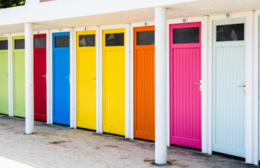 Row of public changing cubicles with colorful doors on the beach of Trestraou in Perros-Guirec, Brittany, France.
