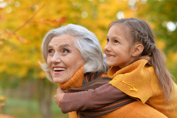 Grandmother with her granddaughter in the autumn park