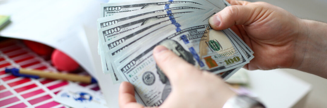 Male hands counting money from huge pack closeup