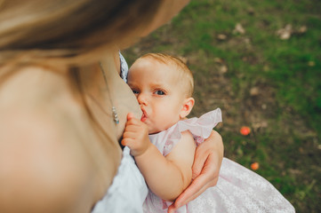 Lovely baby breastfeeding in nature.