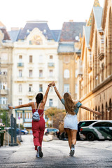 Unrecognizable women walking along tourist city street