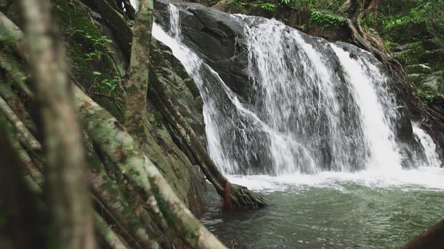 Background Beautiful waterfall in mountains. Traveling along mountains and rain forest. Chet Khot Nature and Ecotourism Center, Saraburi, Asia, Thailand. Dolly shot slide